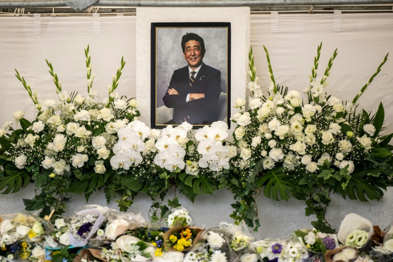 Des fleurs sont déposées sous une photo de l'ancien Premier ministre japonais Shinzo Abe à l'occasion d'une cérémonie dans un temple  un an après sa mort, le 8 juillet 2023 à Tokyo