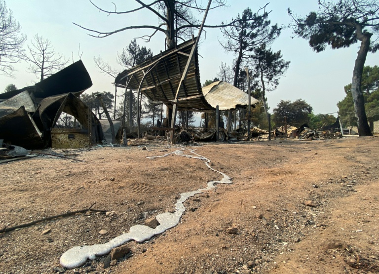 Une traînée de métal en fusion provenant d’un véhicule calciné après un incendie de forêt au camping Pantano de Burguillo, à El Barraco, à 100 kilomètres à l’ouest de Madrid, le 27 juillet 2026
