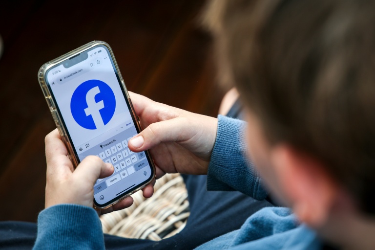 Un adolescent de 14 ans consulte sa page Facebook sur son téléphone portable, le 24 octobre 2025 à Gosford, en Australie