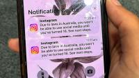 Un adolescent tient un téléphone portable affichant un message du réseau social Instagram après que son compte a été verrouillé en raison de son âge, à Sydney, le 9 décembre 2025