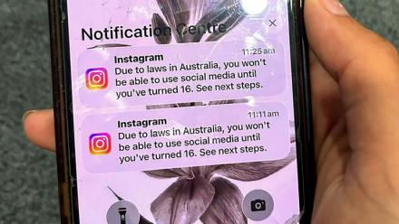 Un adolescent tient un téléphone portable affichant un message du réseau social Instagram après que son compte a été verrouillé en raison de son âge, à Sydney, le 9 décembre 2025