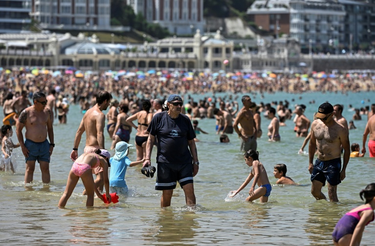 Des personnes se rafraîchissent dans l'eau à la plage de La Concha, dans la ville basque espagnole de Saint-Sébastien, le 21 juin 2026