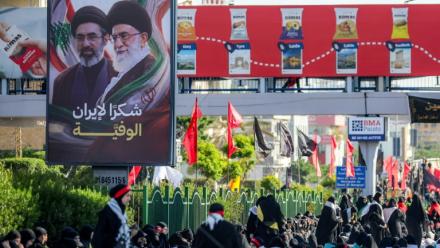 Une affiche représentant le défunt ayatollah Ali Khamenei et son fils l'actuel guide suprême iranien Mojtaba Khamenei est exposée alors que des fidèles chiites se rassemblent pour une procession funèbre, dans la banlieue sud de Beyrouth, le 26 juin 2026