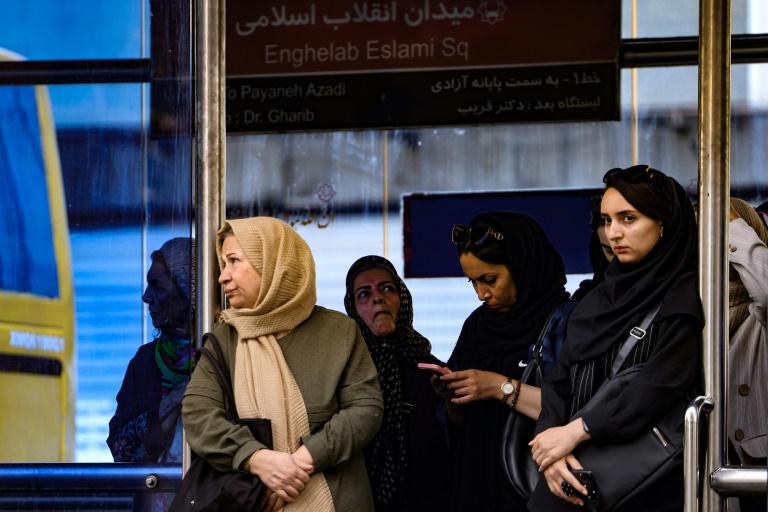 Des Iraniennes attendent devant une station de transport public à Téhéran, le 28 septembre 2025 