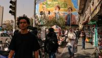 Des passants devant un panneau d'affichage représentant les dirigeants libanais du Hezbollah assassinés Hassan Nasrallah (C) et son successeur Hachem Safieddine (D), ainsi que le général iranien Qassem Soleimani, à Téhéran, le 28 septembre 2025