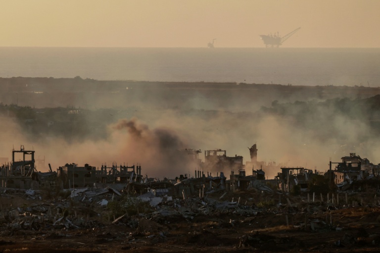 De la fumée est visible au-dessus de bâtiments détruits dans la bande de Gaza lors d'un bombardement israélien, le 21 mai 2025