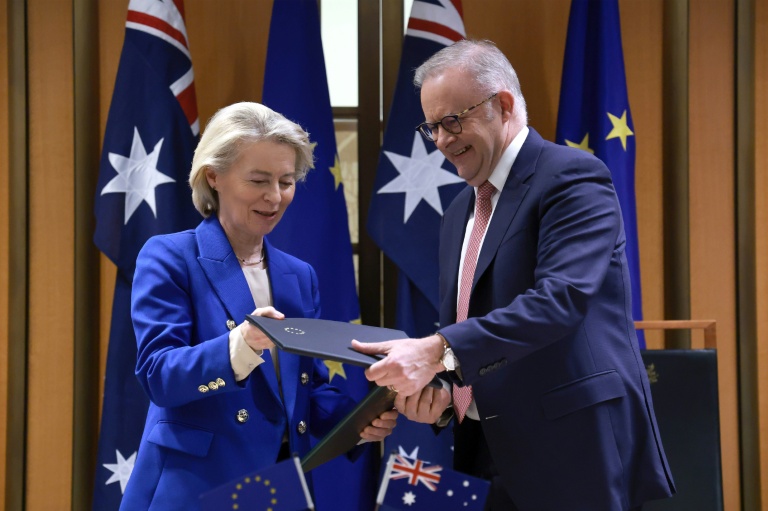 La présidente de la Commission européenne Ursula von der Leyen et le Premier ministre australien Anthony Albanese échangent des copies de l'accord commercial Australie-UE, le 24 mars 2026 à Canberra