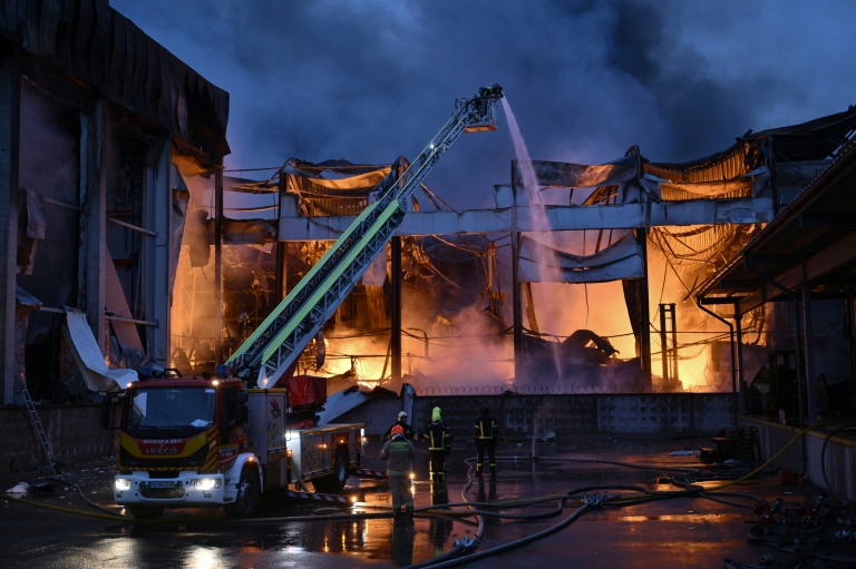 Des pompiers ukrainiens éteignent un incendie dans un entrepôt alimentaire après une frappe russe à Kiev, le 25 octobre 2025