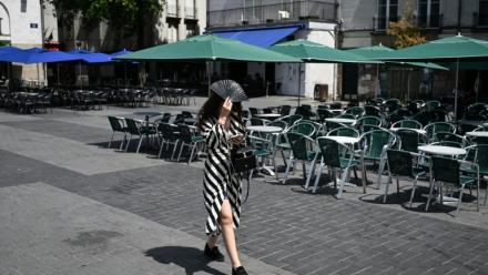 Une passante se protège du soleil avec un éventail, le 23 juin 2026 à Nantes