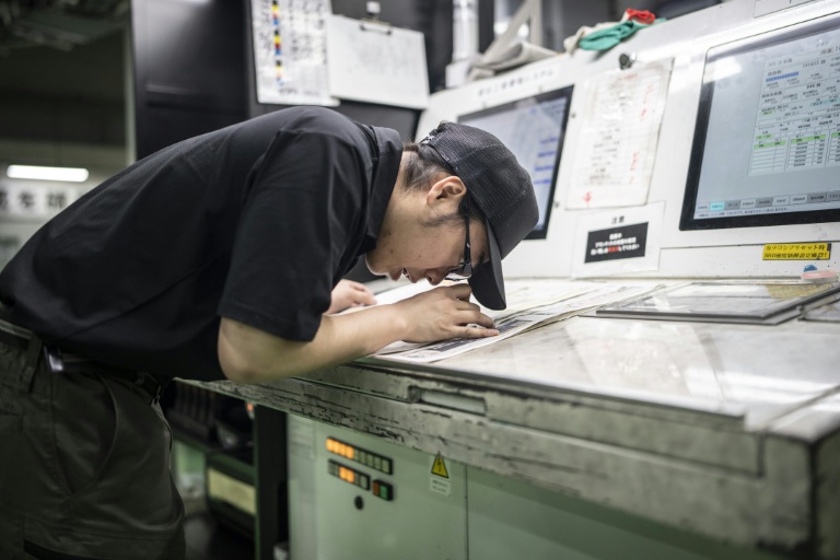 Un employé contrôle la qualité d'impression à l'imprimerie Kyoto Shimbun à Kumiyama, dans la préfecture de Kyoto, le 19 mars 2026 au Japon