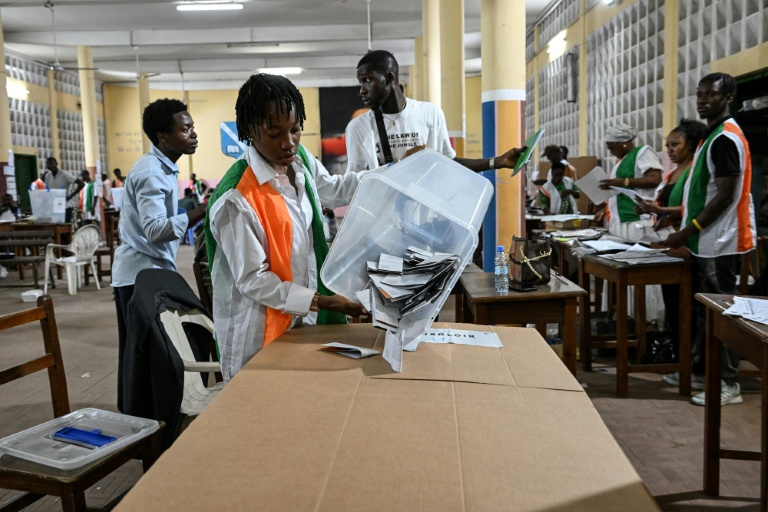 Une représentante de la commission électorale vide une urne pour le dépouillement des votes de la présidentielle ivoirienne, le 25 octobre 2025 à Abidjan
