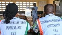 Des représentants de la commission électorale supervisent les opérations de vote pour la présidentielle ivoirienne, à Agboville le 25 octobre 2025
