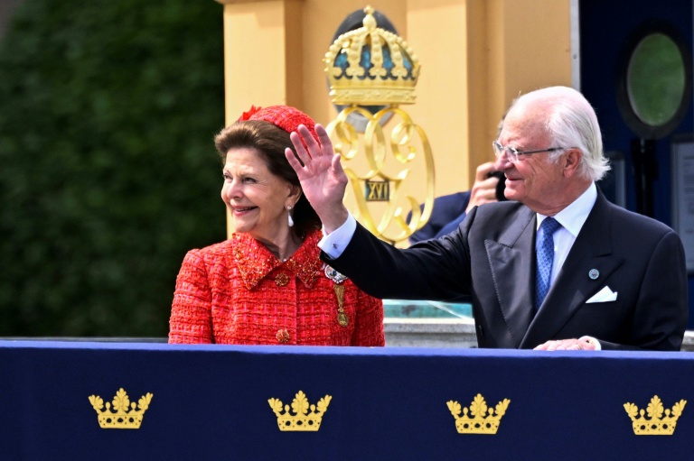 Le roi Carl XVI Gustaf et la reine Silvia de Suède saluent la foule depuis un balcon avant d'embarquer à bord de la barge royale Vasaorden à l'occasion de leurs noces d'or à Stockholm, le 13 juin 2026