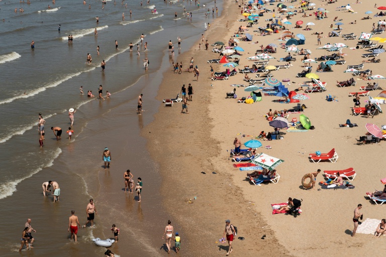 Des personnes se rafraîchissent au bord de la mer sur la plage de Zuiderstrand, à La Haye, aux Pays-Bas, le 26 juin 2026, alors que le service météorologique néerlandais (KNMI) a émis une alerte rouge pour chaleur extrême dans toutes les provinces