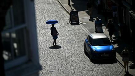 Une personne se protège du soleil le 25 juin 2026 à Guildford, au Royaume-Uni