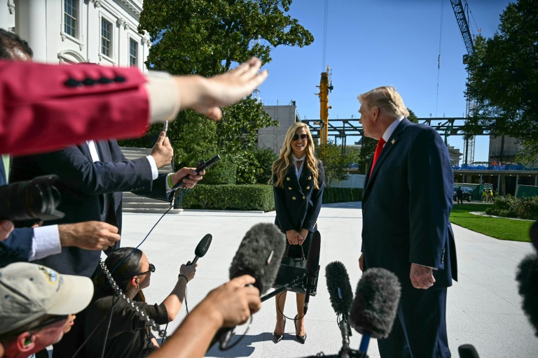 Le président américain Donald Trump se tourne vers la nouvelle porte-parole de la Maison Blanche, Kate Zacharia, devant la presse à Washington le 13 octobre 2026