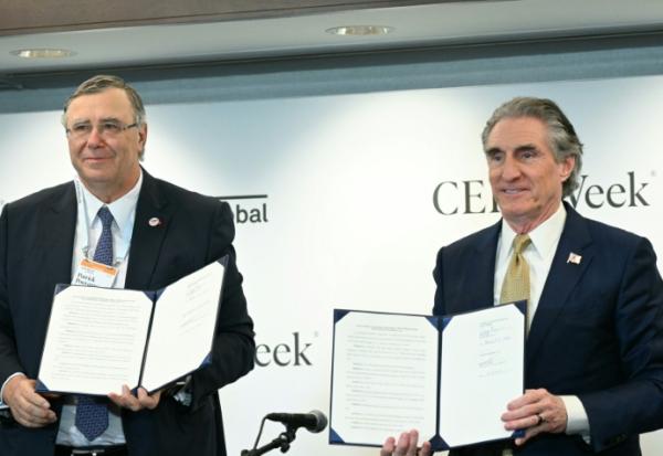     Patrick Pouyanné, patron de TotalEnergies (G) et le ministre américain de l'Intérieur Doug Burgum (D) signent un accord à Houston lors d'une conférence sur l'énergie, le 23 mars 2026