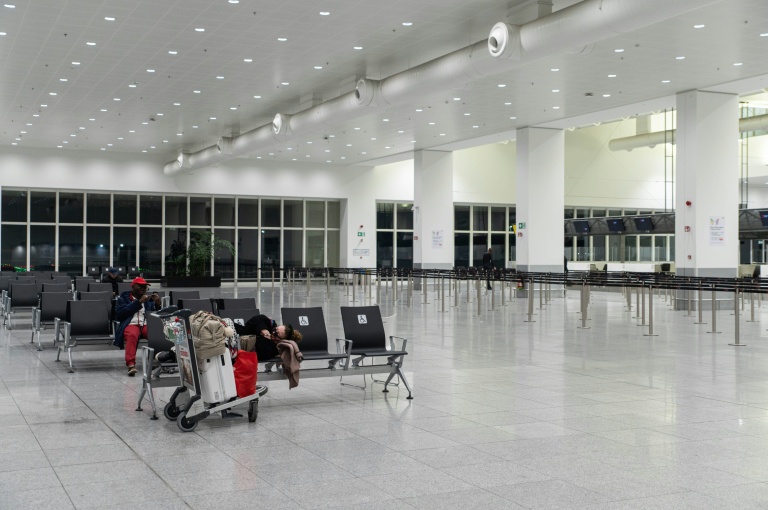 Des passagers attendent dans le hall vide des départs de l'aéroport de Bruxelles-Zaventem, le 4 novembre 2025