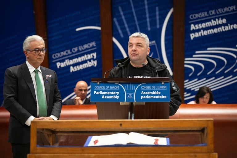 Le journaliste ukrainien Maxime Boutkevitch (c) et le président de l'Assemblée parlementaire du Conseil de l'Europe Theodoros Roussopolos (g), à Strasbourg le 29 septembre 2025 