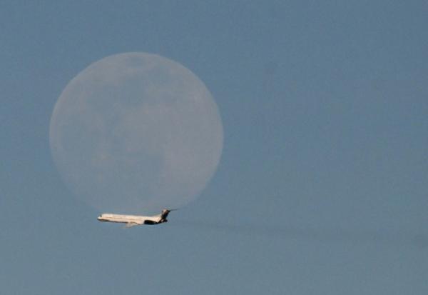 Un avion de la compagnie vénézuélienne Rutaca passe devant la lune, vu depuis l'aéroport international Simon Bolivar à Maiquetia, Venezuela, le 3 décembre 2025