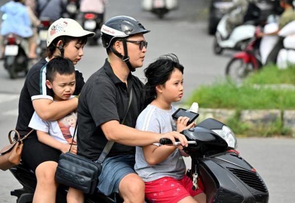 Une famille se déplace en motocyclette, le 4 juin 2025 à Hanoï
