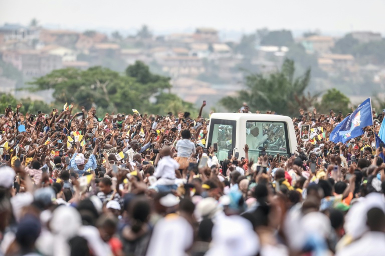 Le pape Léon XIV (C) salue la foule depuis la papamobile à son arrivée à l'aéroport de Yaoundé Ville, au sixième jour d'un voyage apostolique de 11 jours en Afrique, le 18 avril 2026.