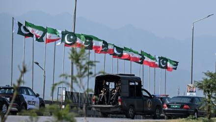 Des drapeaux iraniens et pakistanais le long de la route empruntée par le cortège du président iranien Massoud Pezeshkian à son arrivée à Islamabad, le 23 juin 2026 au Pakistan