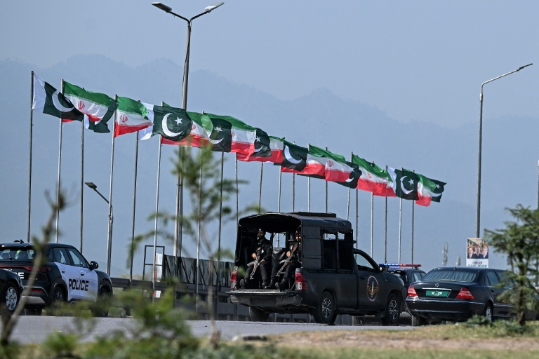Des drapeaux iraniens et pakistanais le long de la route empruntée par le cortège du président iranien Massoud à son arrivée à Islamabad, le 23 juin 2026 au Pakistan