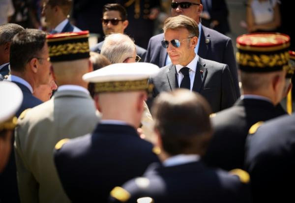 Le président Emmanuel Macron (c) salue des officiers supérieurs à l'issue du traditionnel discours aux armées à l'hôtel de Brienne, à Paris, le 13 juillet 2026, à la veille du défilé annuel du 14 Juillet