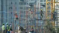 Des travailleurs sur un immeuble en construction à Bengaluru, en Inde, le 27 février 2025