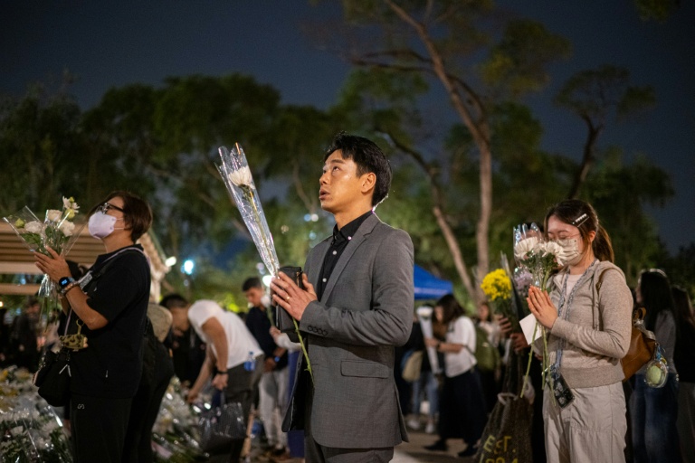 Des personnes se recueillent le 2 décembre 2025 à Hong Kong devant un complexe résidentiel dont l'incendie a fait au moins 159 morts le 26 novembre
