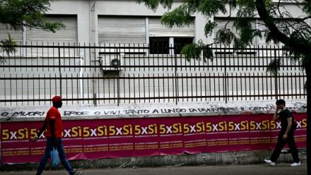 Des gens passent devant des affiches invitant à voter pour le référendum, à Rome, le 5 juin 2025
