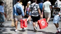 Des passants portent des sacs de courses à Paris, le 25 juin 2025, premier jour des soldes d'été en France
