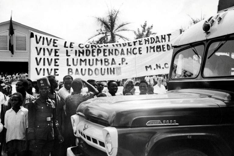 Photo prise le 18 décembre 1960 à Stanleyville (aujourd'hui Kisangani) montrant des Congolais brandissant une banderole proclamant l'indépendance du Congo et soutenant le leader Patrice Lumumba, lors de la visite du roi Baudouin de Belgique dans l'ancienne colonie du Congo belge, devenue République démocratique du Congo (RDC)