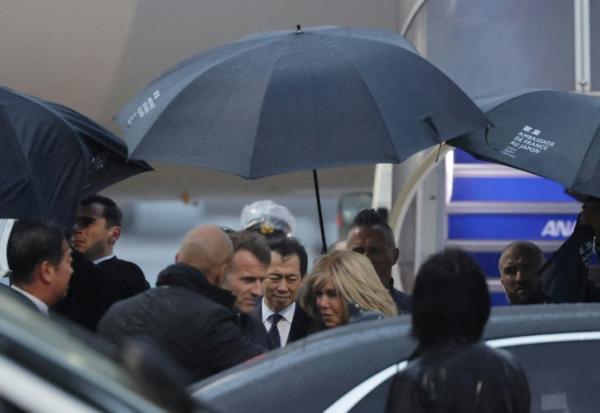 Le président français Emmanuel Macron (c,g) et son épouse Brigitte Macron à leur arrivée à l'aéroport de Tokyo, le 31 mars 2026