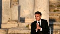 Le président français Emmanuel Macron salue le public à son arrivée sur scène lors d'un événement à l'Agora romaine d'Athènes, le 24 avril 2026 en Grèce