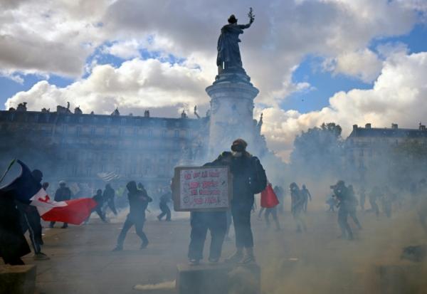 Des protestataires dans la fumée de gaz lacrymogènes lors d'une manifestation contre la vie chère place de la République à Paris, le 17 octobre 2026