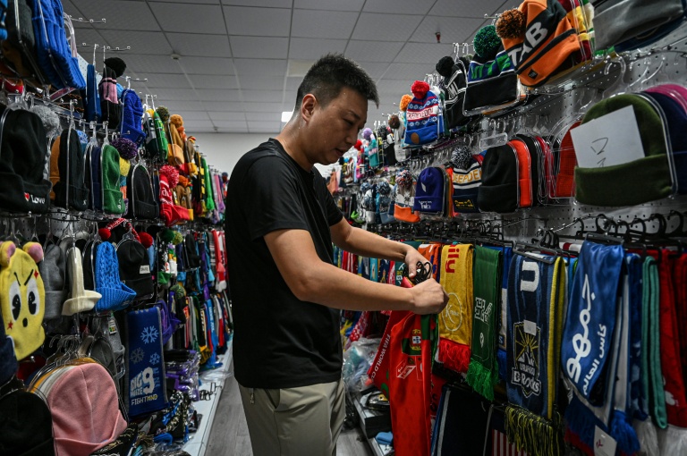 Shang Yabing, le directeur, trie des produits dans une salle d'exposition d'une usine qui produit des chapeaux et des écharpes à Yiwu, dans la province du Zhejiang, dans l'est de la Chine, le 18 septembre 2025