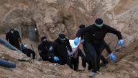 Des combattants armés et cagoulés du Hamas transportent un corps retrouvé dans un tunnel au nord de Khan Younès, dans le sud de la bande de Gaza, le 28 octobre 2025 