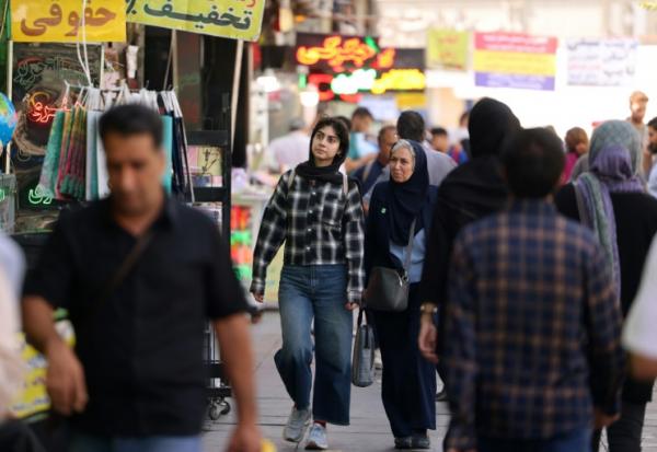 Des passants dans une rue animée de Téhéran, le 28 septembre 2025 en Iran