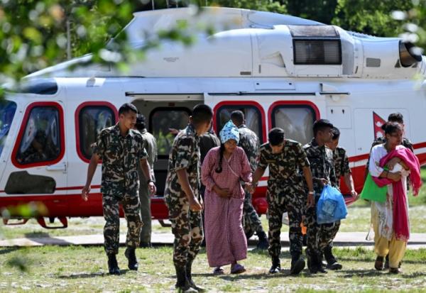 Des militaires soutiennent une rescapée, au camp de Trishuli, dans le district de Nuwakot au Népal, le 28 août 2026