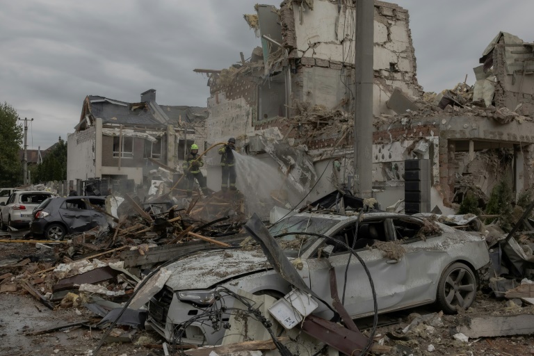 Des sauveteurs dans les décombres d'immeubles résidentiels touchés par une attaque de drones et missiles russes, dans les environs de Kiev, le 28 septembre 2025 en Ukraine