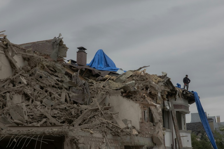 Un homme sur le toit d'un immeuble résidentiel endommagé par un bombardement russe dans la banlieue de Kiev le 28 septembre 2025.