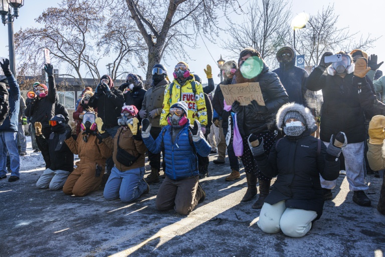 Des manifestants agenouillés et les mains levés protestent contre l'usage de la force par la police à Minneapolis (Minnesota), le 24 janvier 2026, après la mort par balle d'un Américain de 37 ans, tué par des agents fédéraux