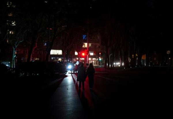 Des piétons dans une rue obscure à Barcelone, en Espagne, pendant une panne d'électricité massive affectant la péninsule ibérique et le sud de la France, le 28 avril 2025