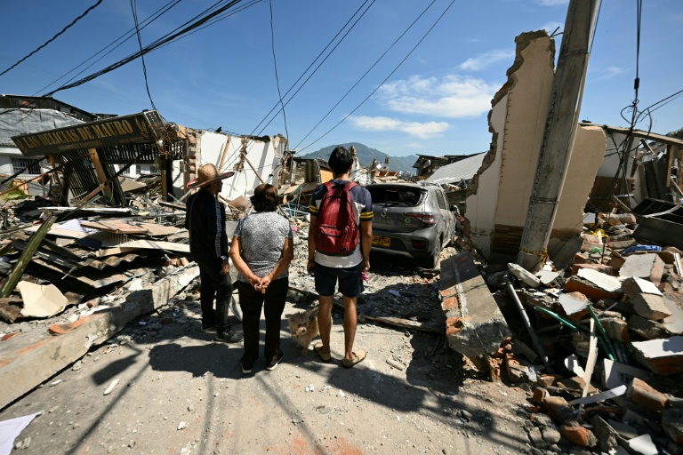Des voisins observent un bâtiment effondré après le séisme à Pereira, en Colombie, le 11 août 2026