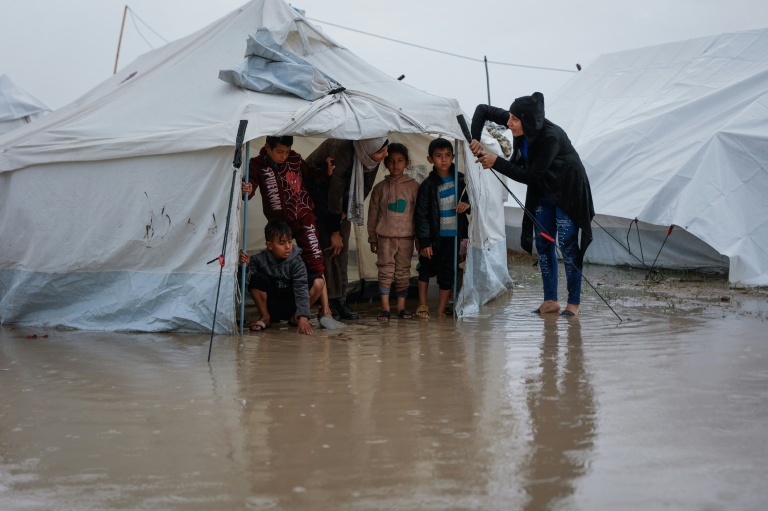Des enfants sous une tente dans un camp du quartier de Zeitoun, à Gaza-ville, inondé après le passage de la tempête Byron, le 11 octobre 2025