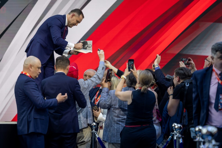 Le candidat à la présidentielle Karol Nawrocki signe son livre pour ses partisans lors d'un meeting de campagne à Jasionka, le 27 mai 2025 en Pologne