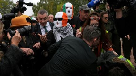 Les membres du groupe Kneecap, dont le chanteur Liam O'Hanna, alias Mo Chara, portent des cagoules aux couleurs du drapeau irlandais à leur arrivée au tribunal de Woolwich, à Londres, le 26 septembre 2025