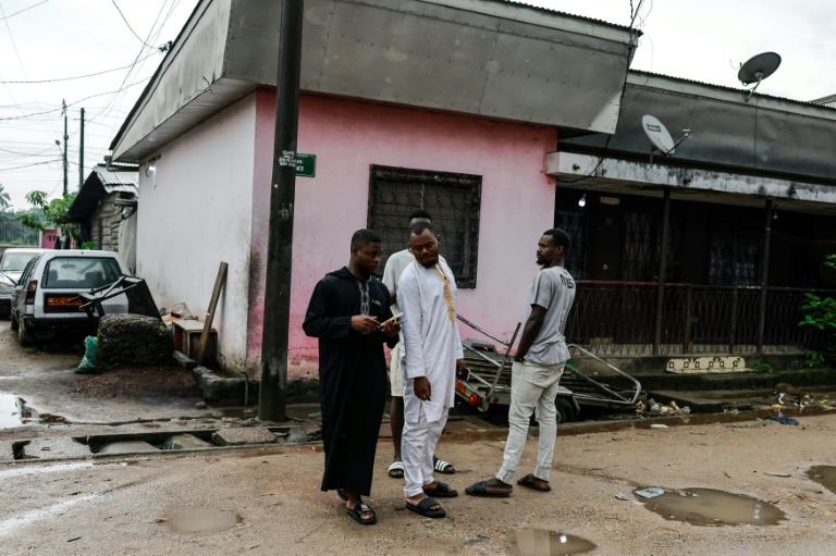 Des amis et des proches se tiennent près du domicile de Mohamed Pouamou, un chauffeur camerounais de 22 ans victime collatérale d'une manifestation ayant suivi la réélection contestée de Paul Biya, le 31 octobre 2025 à Douala
